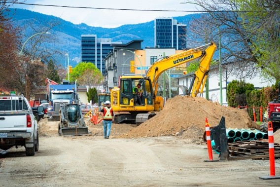 Excavator and work crew building roads and infrastructure in an Okanagan city